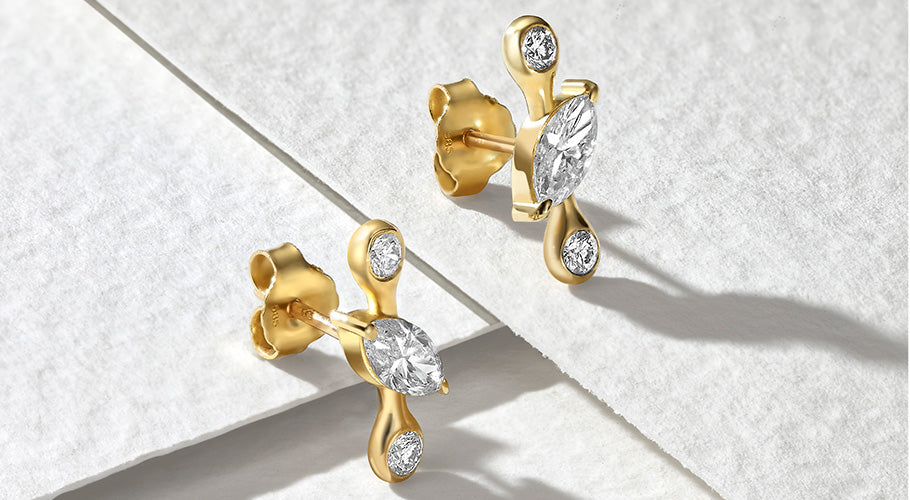 ANNOORY 14k gold diamond stud earrings on recycled paper background